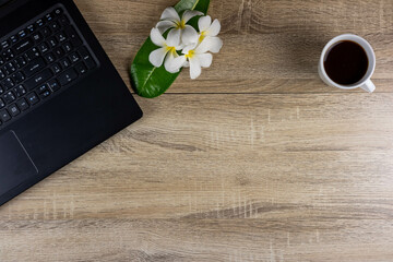 Top view of laptop, notebook, glasses, coffee mug on wooden table for concept work from home, To-do list, Business home.