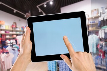 Smart store management systems concept. Manager using digital tablet on blurred store as background