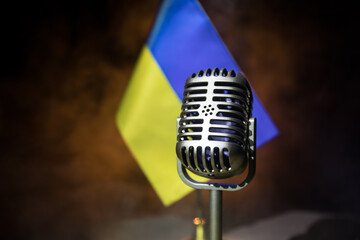 Fototapeta na wymiar Microphone on a background of a blurry flag Ukraine close-up