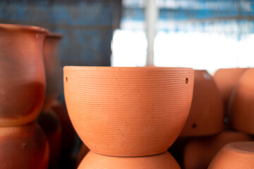 Stacks of orange various terracotta pots for plants for sale at a garden store.