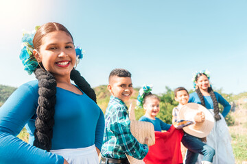 Group of Latino teens, men and women, dressed in traditional country clothing posing on a mountain in Nicaragua smiling and looking at the camera