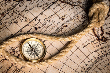 Naklejka na ściany i meble Old golden compass on the antique and vintage mundi map. 