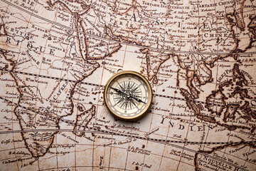 Obraz na płótnie Canvas Old golden compass on the antique and vintage mundi map. 