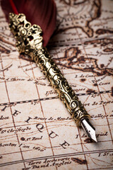 Feather pen on the vintage and antique mundi map.