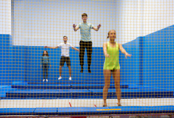 View of yellow safety net in trampoline sports center with blurred young people training on background