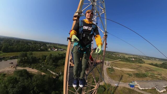 jumping with a climbing rope from a tower 50 meters high performing a somersault trick shooting on an action camera, a man doing a somersault from a tower