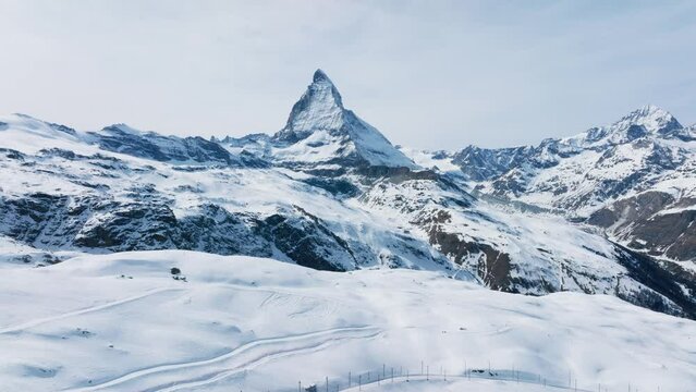 Scenic view of snowcapped Matterhorn mountain peak. Beautiful snow covered white landscape against sky. Alpine region during winter.