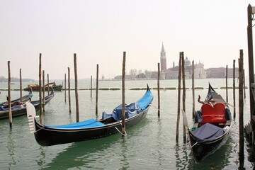 Fototapeta na wymiar Clásicas góndolas negras ancladas en lago de Venecia con Basílica de fondo