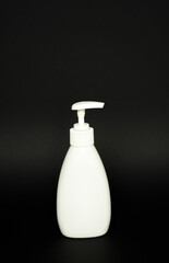 White plastic bottle used for shampoo or soap on black background.. Mock up template for design.