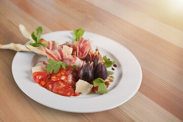 Traditional spanish jamon, prosciutto crudo, italian salami, parma ham on a plate.