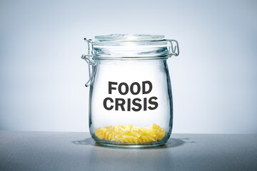Some pasta in glass jar and letteting FOOD CRISIS. Food shortages concept.