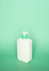 Large white plastic bottle with pump dispenser as a liquid container for gel, lotion, cream, shampoo, bath foam on pink background.