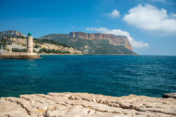 Fototapeta na wymiar Panoramic view on cliffs, blue sea, beach, houses, streets and old fisherman's harbour with lighthouse in Cassis, Provence, France
