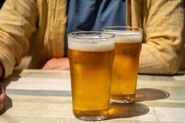 Men with two glasses of fresh cold lager beer in French outdoor cafe