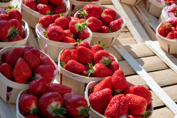 Sweet ripe french red strawberries in wooden boxes on Provencal farmers market, Cassis, France.