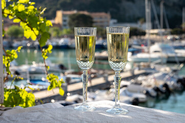 Birthday celebration with two glasses of French champagne sparkling wine and view on colorful fisherman's boats in old harbour in Cassis, Provence, France