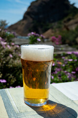 Glass of fresh cold lager beer served outdoor in snack bar with view on Calanque de Figuerolles in La Ciotat, Provence, France