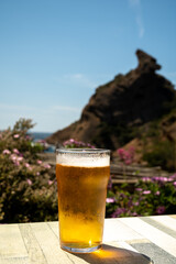 Glass of fresh cold lager beer served outdoor in snack bar with view on Calanque de Figuerolles in La Ciotat, Provence, France - obrazy, fototapety, plakaty
