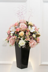 colorful bouquet of flowers decorated with leaves and branches in a black vase, nature as decoration and romantic gift, style and elegance