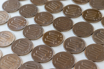白い机の上に並べられたたくさんの百円硬貨