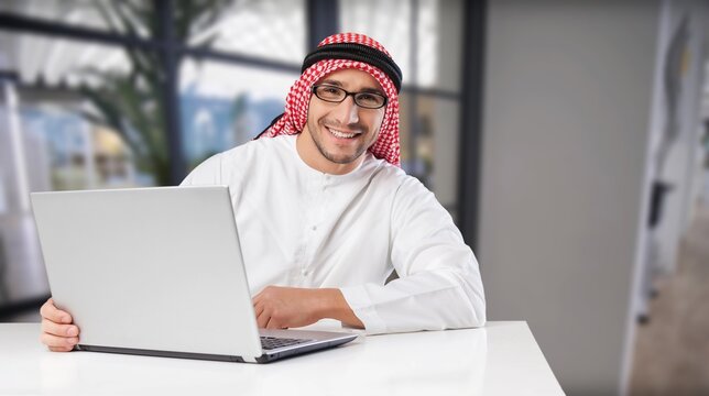 Handsome man with dish dasha working in his business office. Portraits of a successful businessman in traditional emirates white dress.