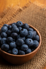ナチュラルな木の器に盛ったたくさんのブルーベリー