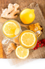 Fototapeta na wymiar Ginger tea with lemon and honey in crystal glass on wooden table
