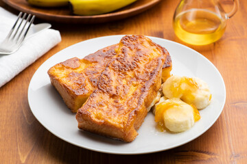 朝食のテーブルの上にバナナとオレンジマーマレードを添えたカリカリ食感のキャラメルフレンチトースト