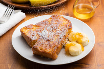 朝食のテーブルの上にバナナとオレンジマーマレードを添えたカリカリ食感のキャラメルフレンチトースト