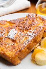 朝食のテーブルの上にバナナとオレンジマーマレードを添えたカリカリ食感のキャラメルフレンチトースト