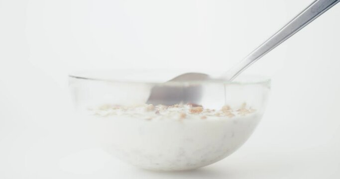 Breakfast granola oats and milk or oatmeal cup on a spoon in close up