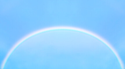 Arched rainbow in blue sky