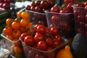 Almaty, Kazakhstan - 03.25.2022 : A variety of tomatoes on a twig lie in containers for sale at the market.