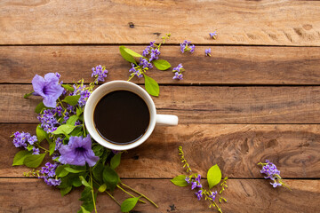 hot coffee espresso with little purple flowers arrangement flat lay postcard style on background wooden