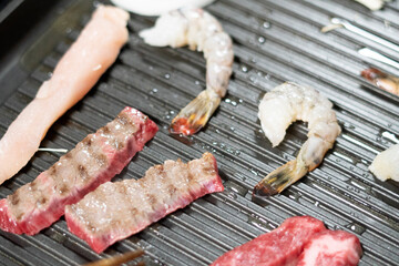 鉄板で肉や海老を焼く　イメージ