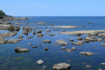 湯野浜海岸の岩場風景 ／ 山形県の湯野浜海岸は、非常にきれいな白砂と奇岩怪石の磯が続く美しい景観のリゾート地です。湯野浜は全国の名所の中から「日本の夕陽百選」にも選ばれたエリアです。日本海に沈む夕陽は大変素晴らしい景観で、日本海トップランクのリゾート地として、五感の全てを満たす多くの魅力にあふれたエリアです。