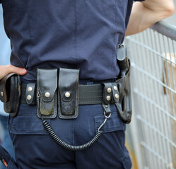 Security guard with guns and scabbard during surveillance outside the bank and a metal barrier