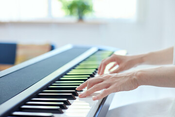 Fototapeta premium リビングでピアノを弾く日本人の女性