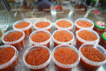 Almaty, Kazakhstan - 03.25.2022 : Sale of red caviar in plastic containers on the market.