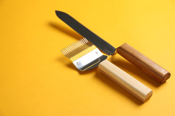 Uncapping fork and knife on yellow background, space for text. Beekeeping tools