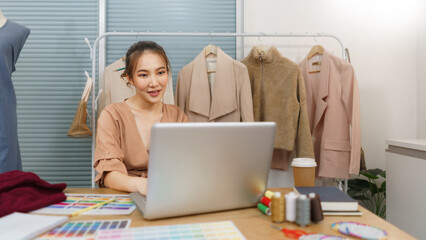 Fashion design concept, Asian female designer use laptop to searching data for new collection