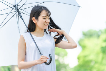 傘を持って悩む女性（梅雨）

