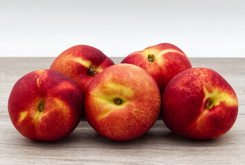 Ripe red peaches isolated on wooden table