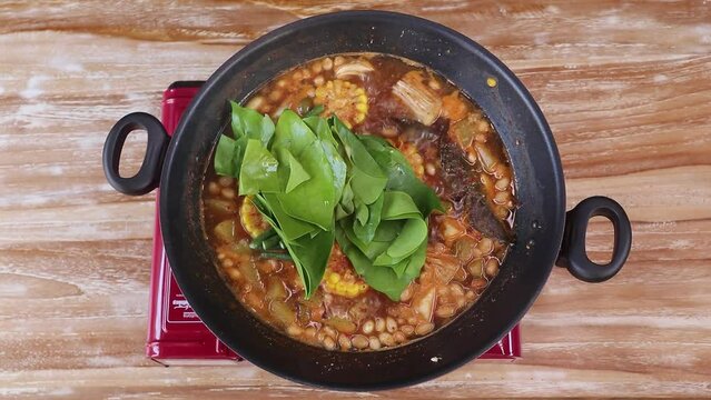 Putting long beans and belinjo leaves to make tamarind vegetables. tamarind vegetable soup