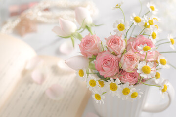 Obraz na płótnie Canvas 読書のイメージ、淡いピンクの花束と本