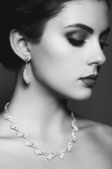 Fashion portrait of young beautiful woman with jewelry. Black and white photo. Perfect make-up. ...