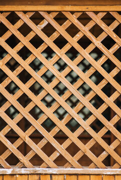 Wooden fence, lattice in rhombuses, squares close-up. Photography, background, concept.