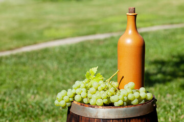 Grapes and wine bottle on wine barrel
