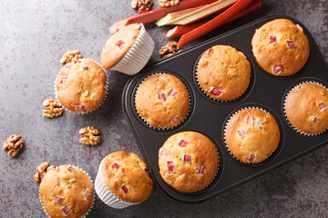 Close-up of muffins with walnuts and rhubarb in a baking dish on the table. horizontal top view from above