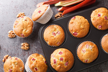 Homemade sweet muffins with rhubarb and walnuts close-up in a baking dish on the table. horizontal...
